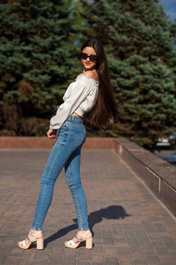 Mavi kot pantolon ve beyaz bluz oldukça şık esmer kız 