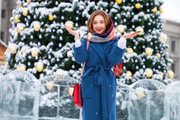 Happy young girl in blue coat posing in winter street — 스톡 사진