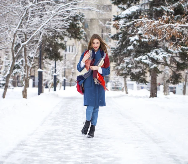 Portrait of young girl in blue jeans walking in a winter park — 스톡 사진