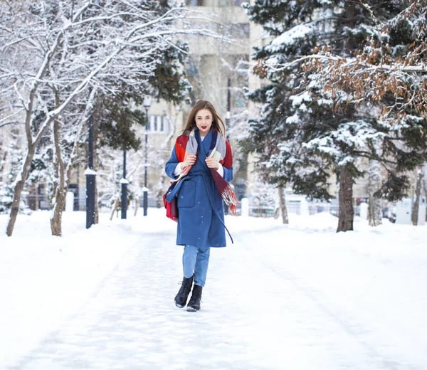 Portrait of young girl in blue jeans walking in a winter park — 스톡 사진