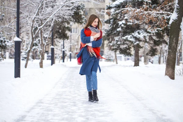 Portrait of young girl in blue jeans walking in a winter park — 스톡 사진