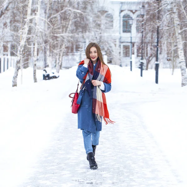 Portrait of young girl in blue jeans walking in a winter park — 스톡 사진