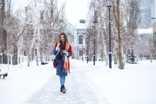 Portrait of young girl in blue jeans walking in a winter park — Stock Photo, Image