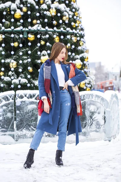 Portrait of young girl in blue jeans walking in a winter park — 스톡 사진