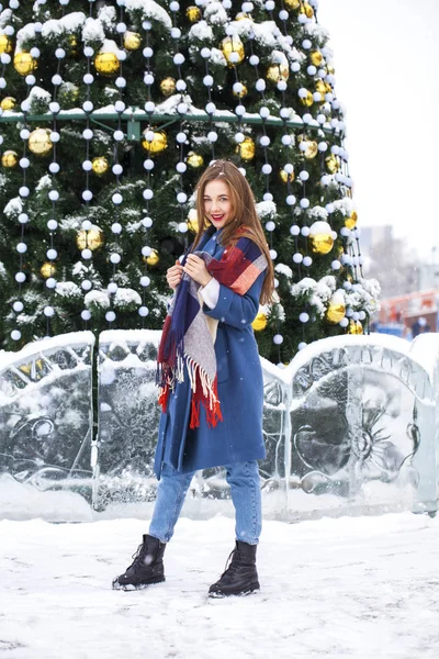 Portrait of young girl in blue jeans walking in a winter park — Stock Photo, Image