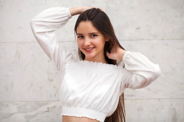 Молода красива дівчина на фоні білої мармурової стіни — стокове фото