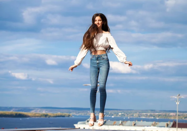 Menina morena muito elegante em jeans azuis e blusa branca — Fotografia de Stock