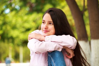 Autum bir arka plan üzerinde pembe ceketli genç bir kızın portresi