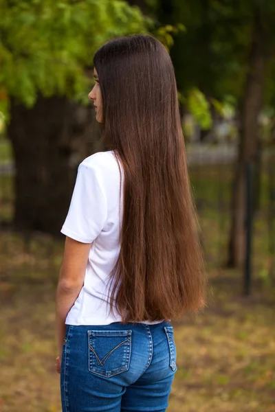 Vrouwelijk brunette haar, achteruitkijk, zomerpark — Stockfoto