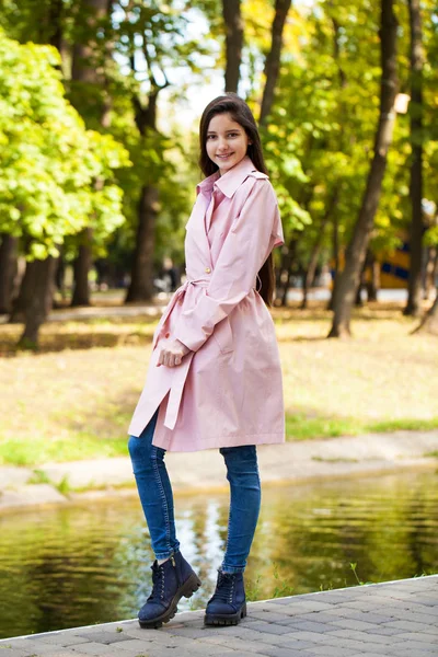 Retrato de una joven morena con abrigo rosa sobre un fondo o —  Fotos de Stock