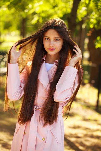 Retrato de una joven morena con abrigo rosa sobre un fondo o —  Fotos de Stock