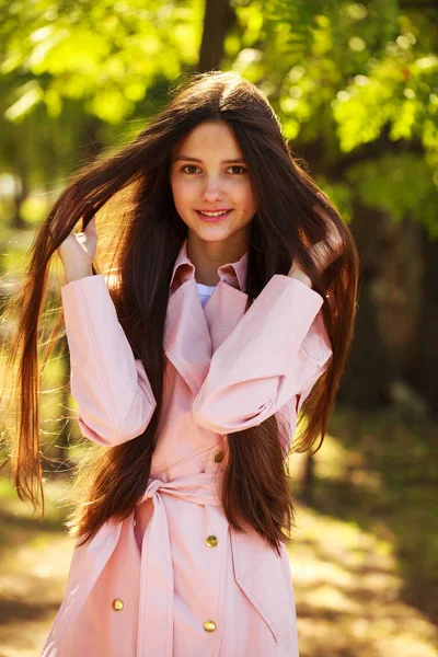 Retrato de una joven morena con abrigo rosa sobre un fondo o —  Fotos de Stock