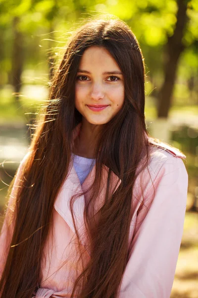 Retrato de una joven morena con abrigo rosa sobre un fondo o —  Fotos de Stock