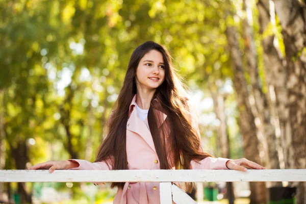 Retrato de una joven morena con abrigo rosa sobre un fondo o — Foto de Stock