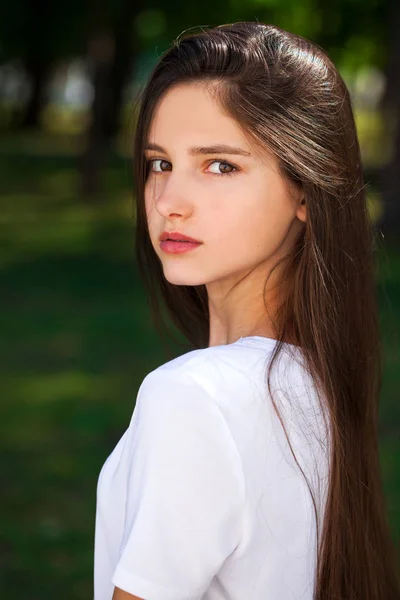 Vackra Brunette flicka i vit t-shirt på en bakgrunds — Stockfoto