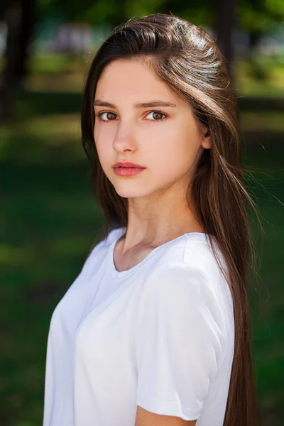 Vackra Brunette flicka i vit t-shirt på en bakgrunds — Stockfoto