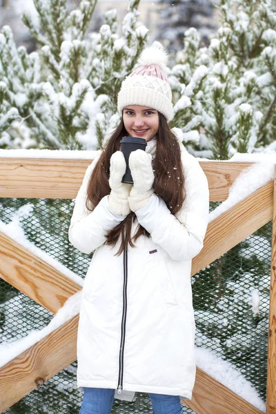 Młoda dziewczyna ze szklanką kawy w zimowym parku — Zdjęcie stockowe