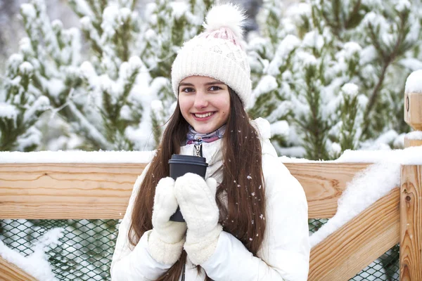 Молода дівчина з келихом кави в зимовому парку — стокове фото