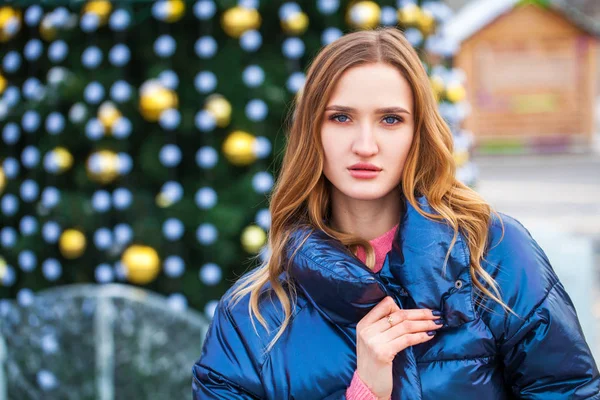 Mladá blondýna žena v modré bundě v zimní ulici — Stock fotografie