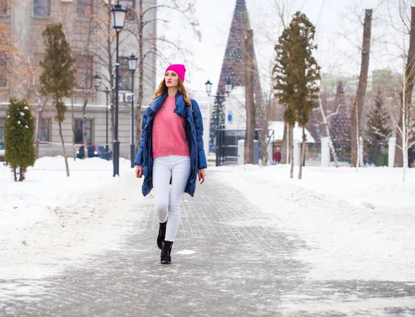 Young blonde woman in blue down jacket in winter street — 스톡 사진