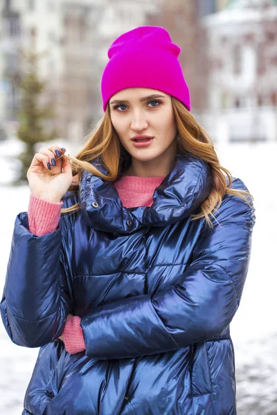 Молода блондинка в синій куртці на зимовій вулиці — стокове фото