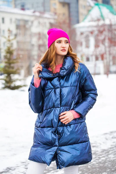 Giovane donna bionda in piumino blu in strada invernale — Foto Stock