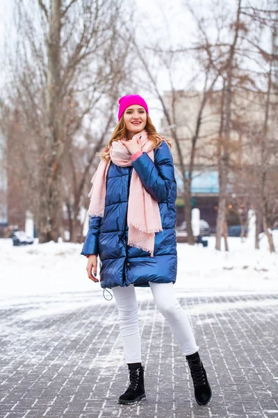 Giovane donna bionda in piumino blu in strada invernale — Foto Stock