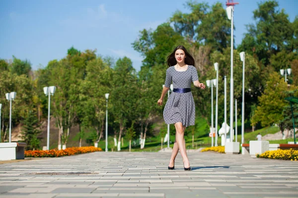 Joven hermosa mujer en vestido gris caminando en la calle de verano — Foto de Stock