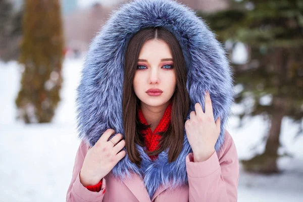 冬天街上穿着蓝色羽绒服的金发年轻女子 — 图库照片