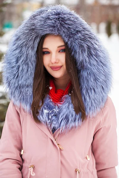 Young blonde woman in blue down jacket in winter street — 스톡 사진