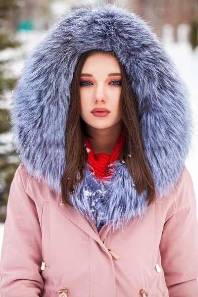 Young blonde woman in blue down jacket in winter street — 스톡 사진