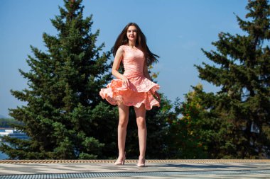 Yaz sokakta yürüyen pembe elbiseli genç güzel kadın