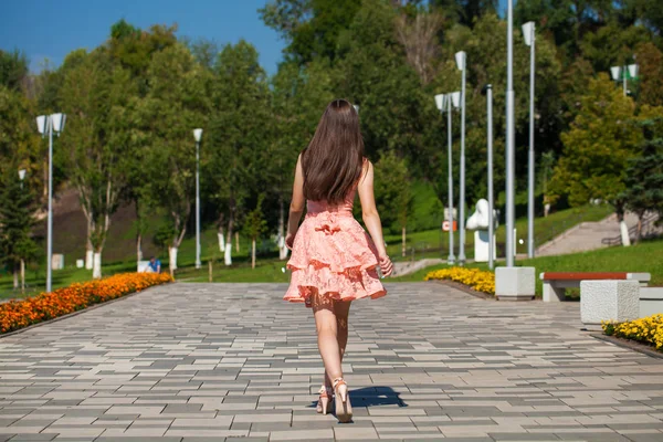 Yaz sokakta yürüyen pembe elbiseli genç güzel kadın — Stok fotoğraf