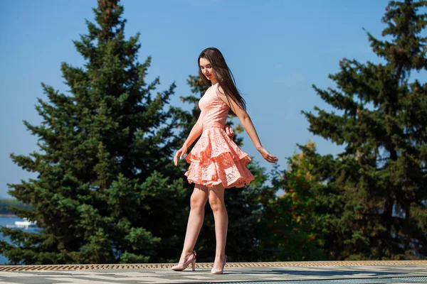 Jeune belle femme en robe rose marchant dans la rue d'été — Photo