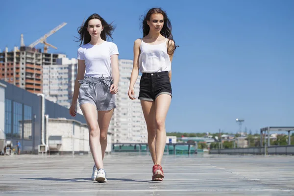 Due amiche che camminano sulla strada estiva, all'aperto — Foto Stock