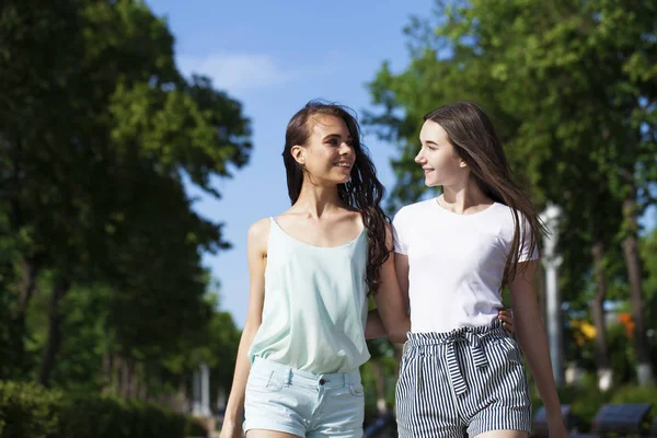 Due amiche che camminano sulla strada estiva, all'aperto — Foto Stock