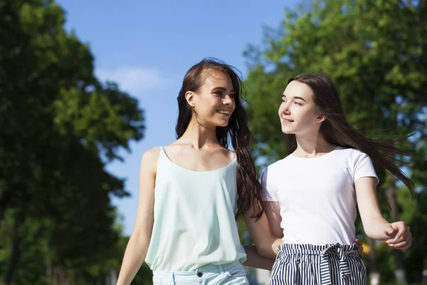 Två flick vänner som går på sommar gatan, utomhus — Stockfoto
