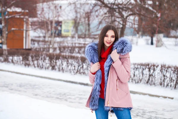 Ung blond kvinna i blå dunjacka på vintern gata — Stockfoto