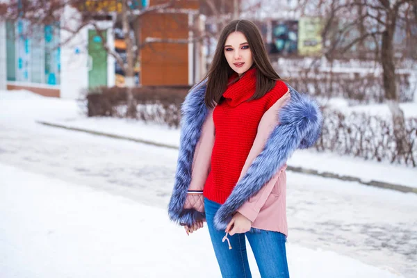 Young blonde woman in blue down jacket in winter street — 스톡 사진