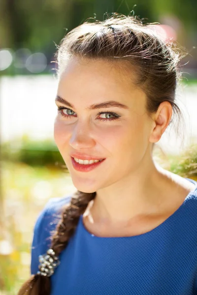 Mladá krásná brunetka v modrých šatech na podzimním parku — Stock fotografie