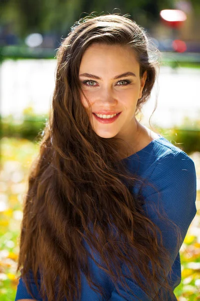 Jonge mooie brunette vrouw in blauwe jurk in herfst Park — Stockfoto