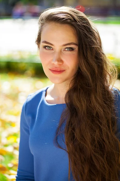 Joven hermosa mujer morena en vestido azul en el parque de otoño —  Fotos de Stock