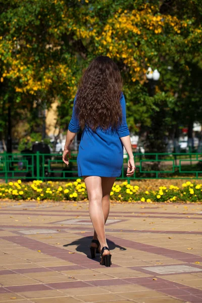 Jovem mulher bonita em vestido azul escuro andando no verão s — Fotografia de Stock