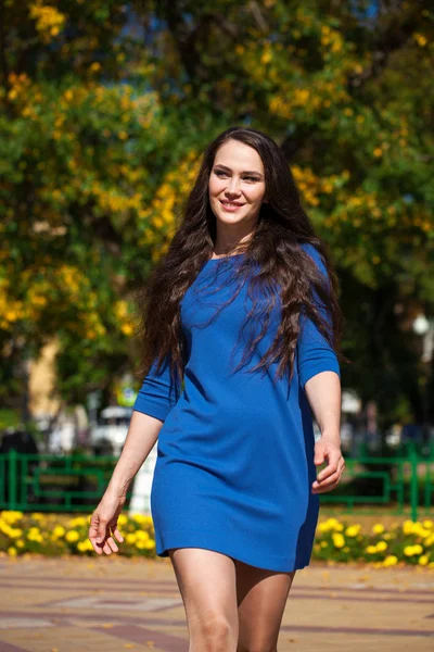 Joven hermosa mujer en vestido azul oscuro caminando en el verano s — Foto de Stock