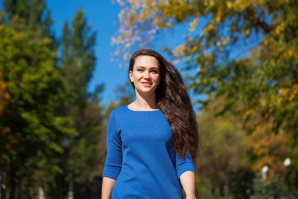 Bella donna bruna in un vestito blu che cammina per strada , — Foto Stock