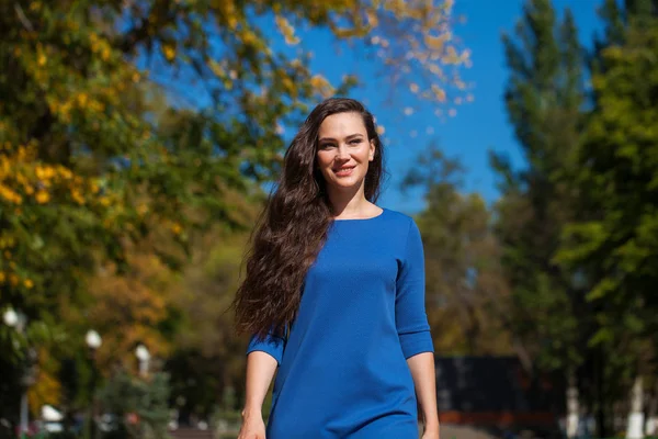 Bella donna bruna in un vestito blu che cammina per strada , — Foto Stock