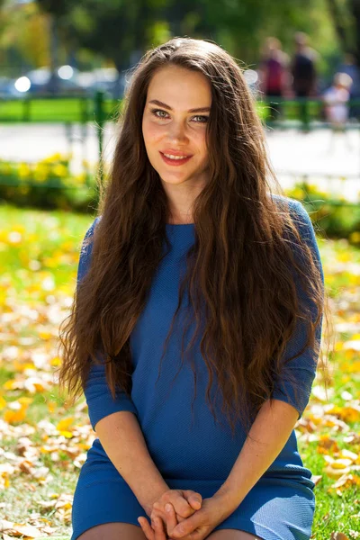 Joven hermosa mujer morena en vestido azul en el parque de otoño —  Fotos de Stock