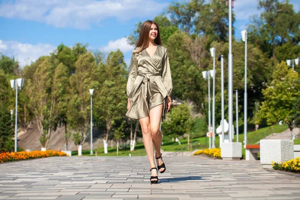 Jovem mulher bonita em vestido verde andando sobre a árvore de verão — Fotografia de Stock