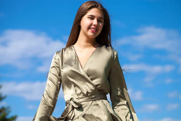 Jovem mulher bonita em vestido verde andando sobre a árvore de verão — Fotografia de Stock