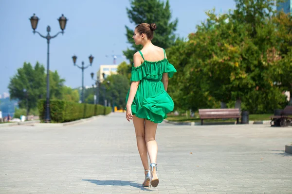 Młoda piękna brunetka dziewczyna w zielonej sukni spacery wzdłuż EMB — Zdjęcie stockowe